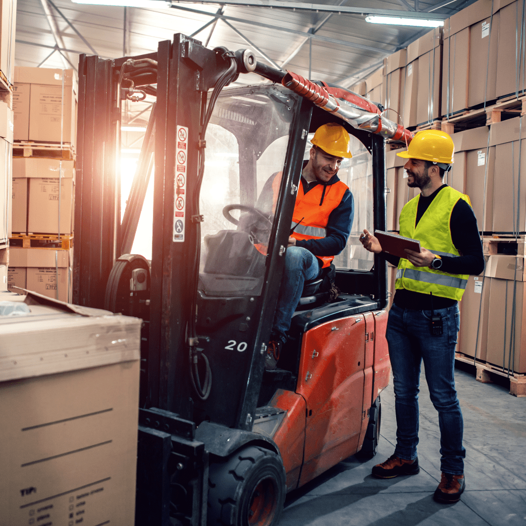 Warehouse worker operating forklift with boxes in background