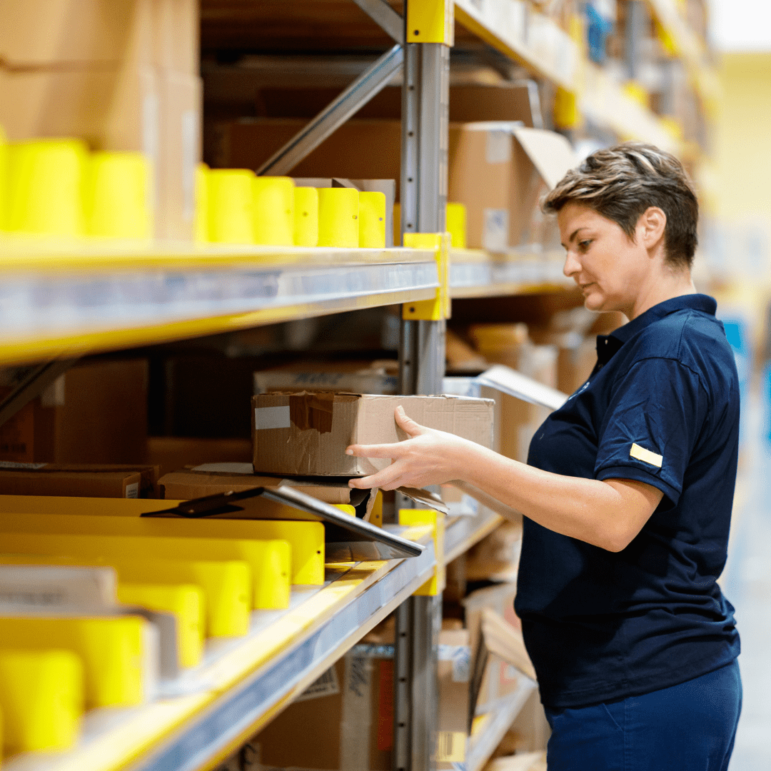 A warehouse worker picking orders from a shelving unit